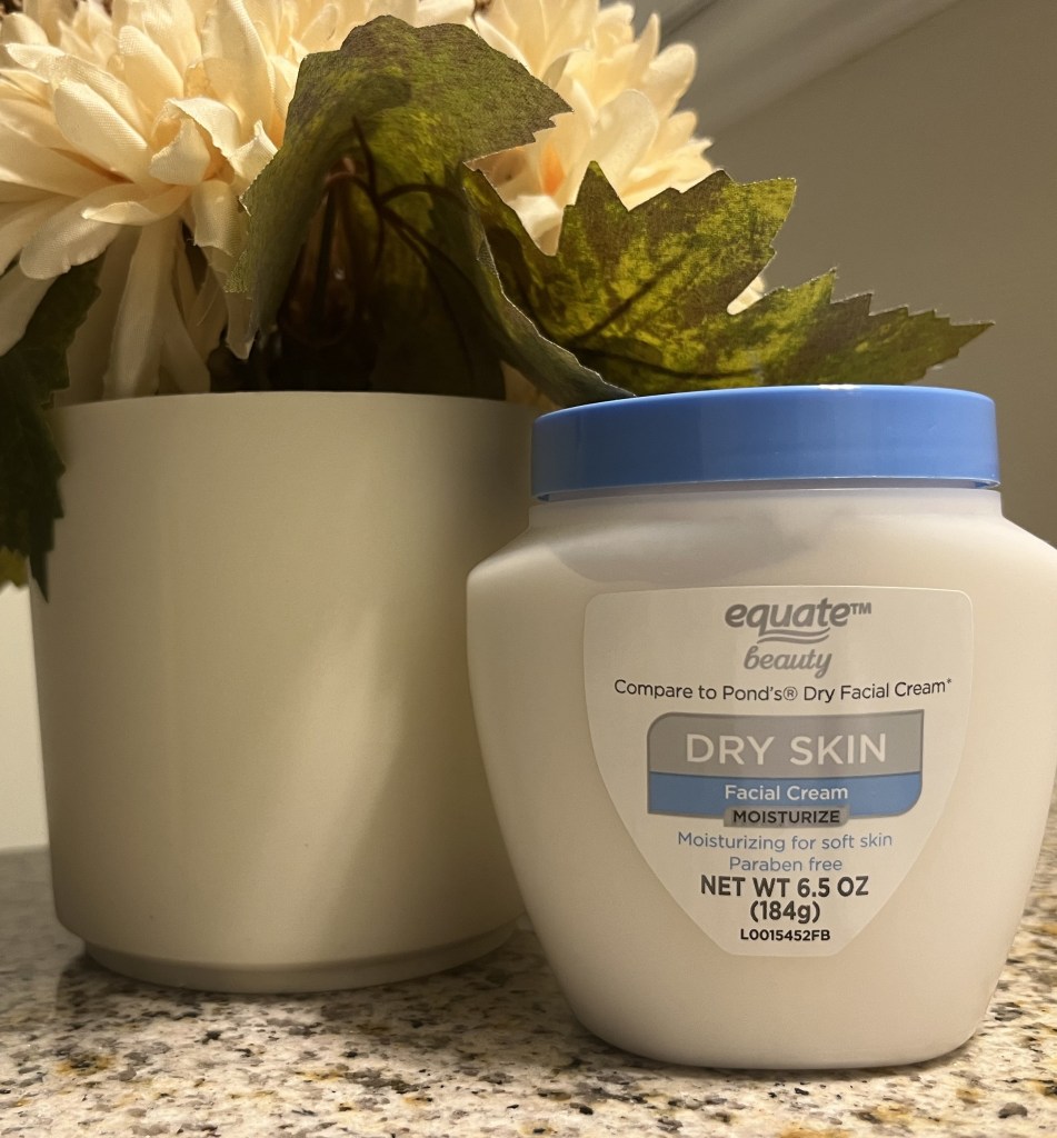 Equate beauty facial cream moisturizer next to a small decorative plant.