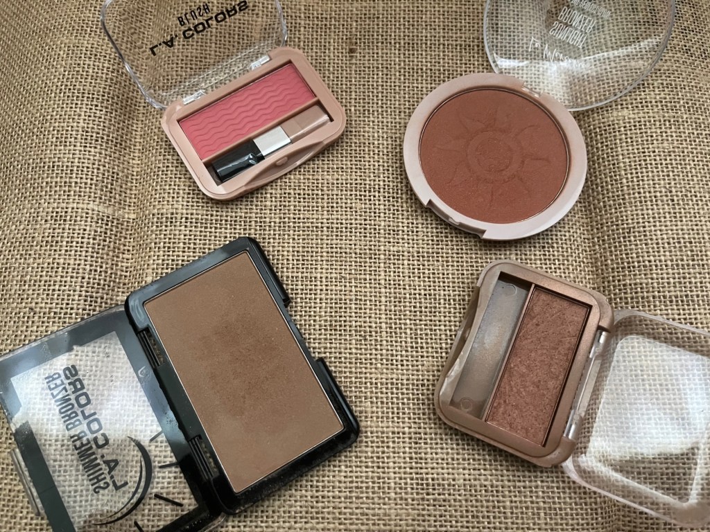 A picture of one L.A. Colors Blush in the color Peony Perfect, L.A. Colors Bronzer in Baked, Le Mercerie Sunlit Bronzer, and an L.A. Colors Blush in Sun Goddess.