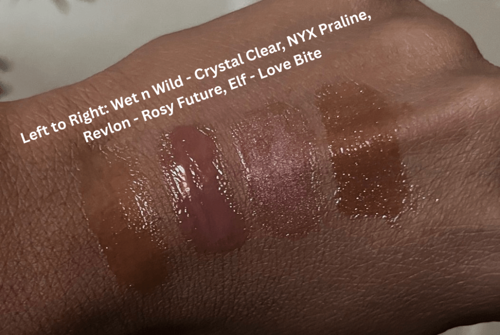 Swatches of drugstore lip glosses on brown skin such as Nyx Praline, Wet n wild Crystal Clear, Revlon Rosy Future, and e.l.f. Love Bite.