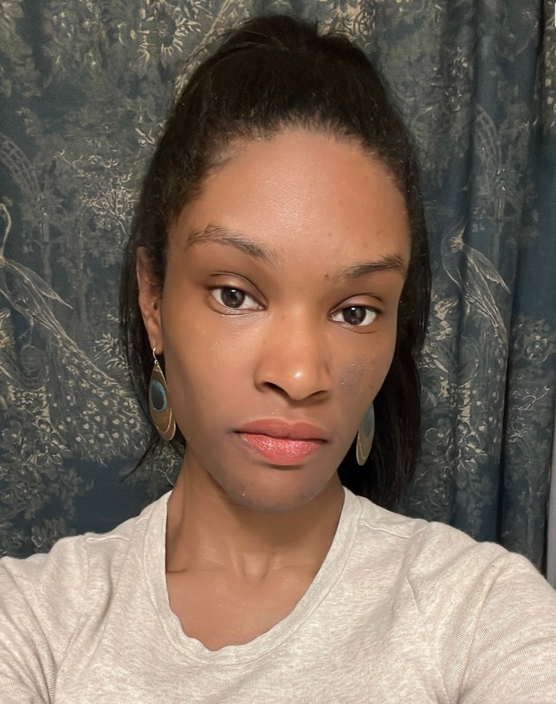 Brown skinned woman wearing Revlon Rum Raisin.